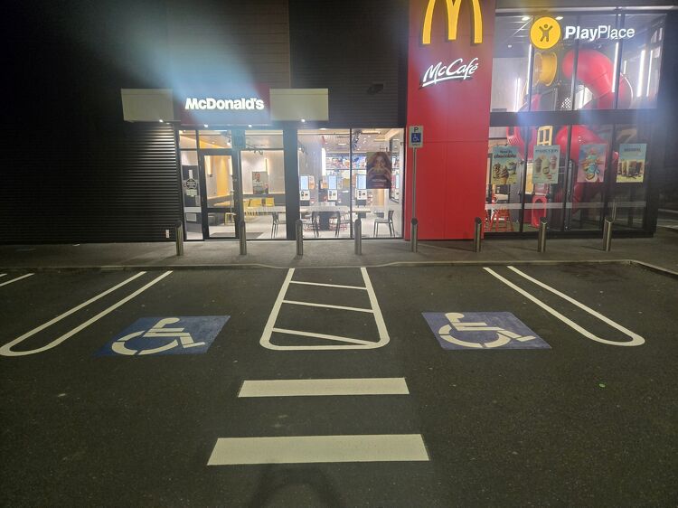 Accessible parking spaces with clear wheelchair symbols and safety markings at McDonald&rsquo;s.