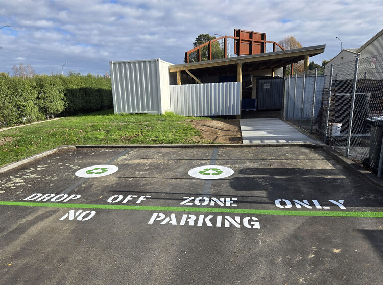 Drop-off zone with green recycling symbols and clear “No Parking” line markings for restricted access.