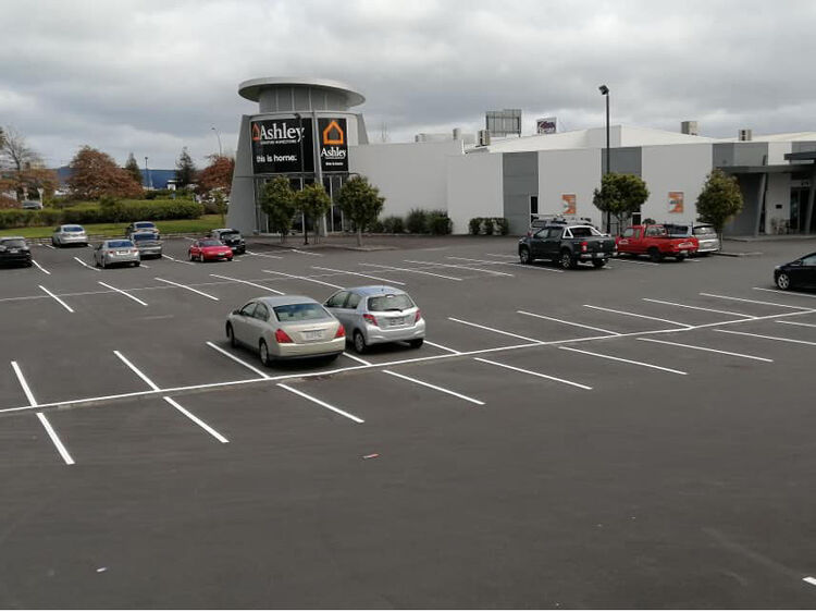 Completed commercial car park with crisp white line markings for improved parking layout.
