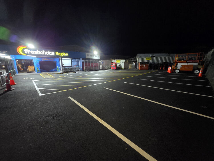 Freshly painted supermarket car park at FreshChoice Raglan with clear yellow line markings at night.