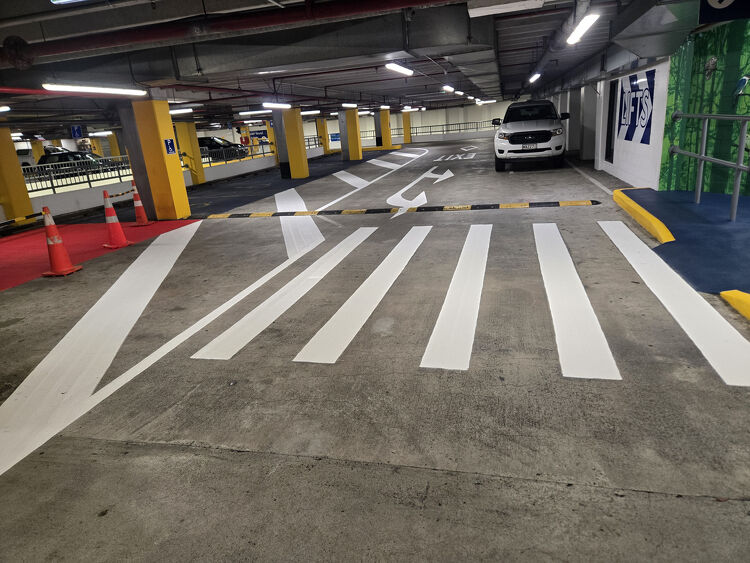 Underground car park exit area featuring new white pedestrian crossings and directional line markings.