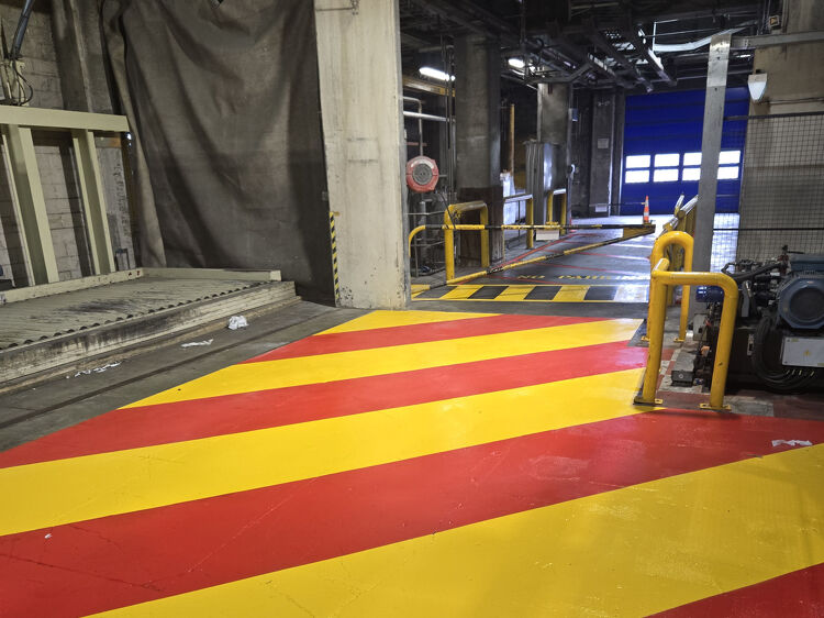 Industrial floor with bold red and yellow safety markings by Accurate Linemarking to define restricted zones.