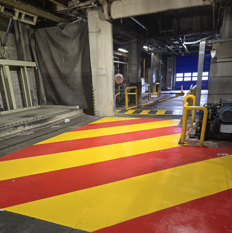 Industrial floor with bold red and yellow safety markings by Accurate Linemarking to define restricted zones.